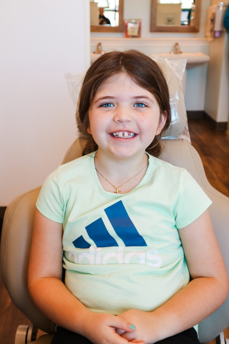 Child sitting in chair smiling for a photo