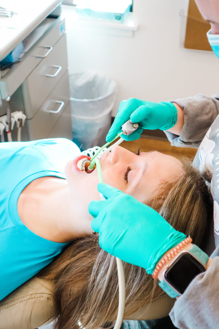 doctor treating patient who is laying in orthodontic chair